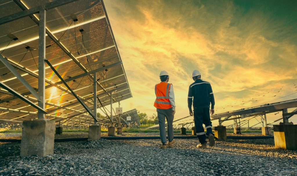 energy inspectors walking amongst ground mounted solar panels in Texas